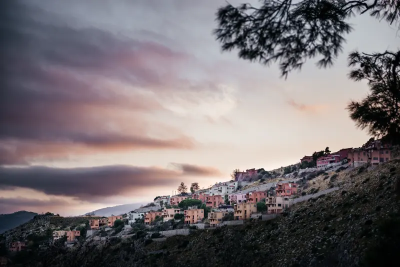 Pizzo Sella's unfinished concrete villas under a pink dusk sky